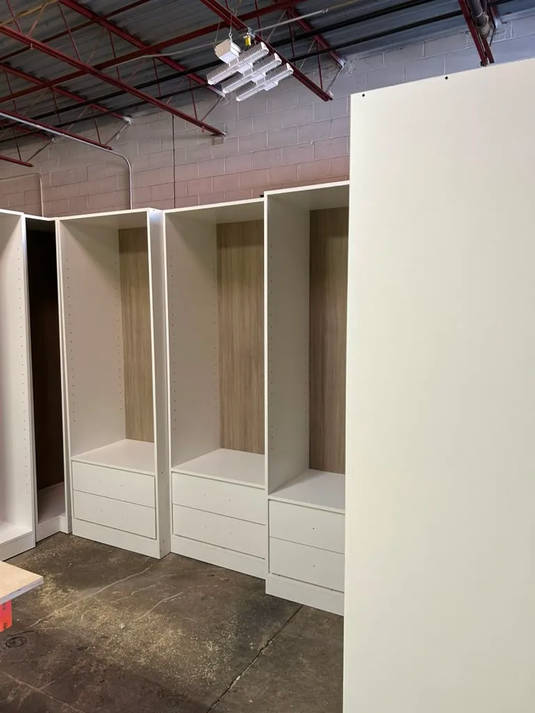 Custom closet drawers with warm wood-grain interior backing