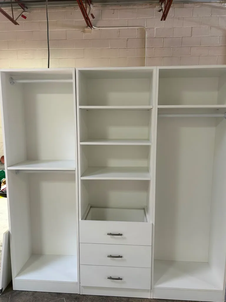 Open custom closet shelving and drawer unit showing cabinetry construction