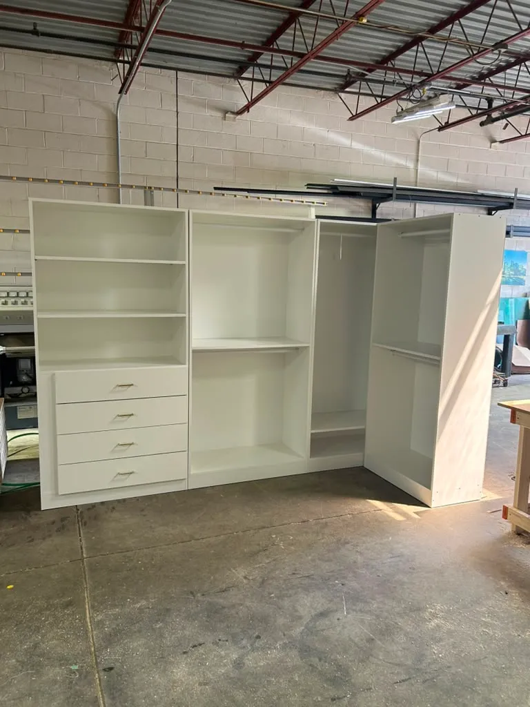 Custom closet system with open shelving, drawers, and hanging rods