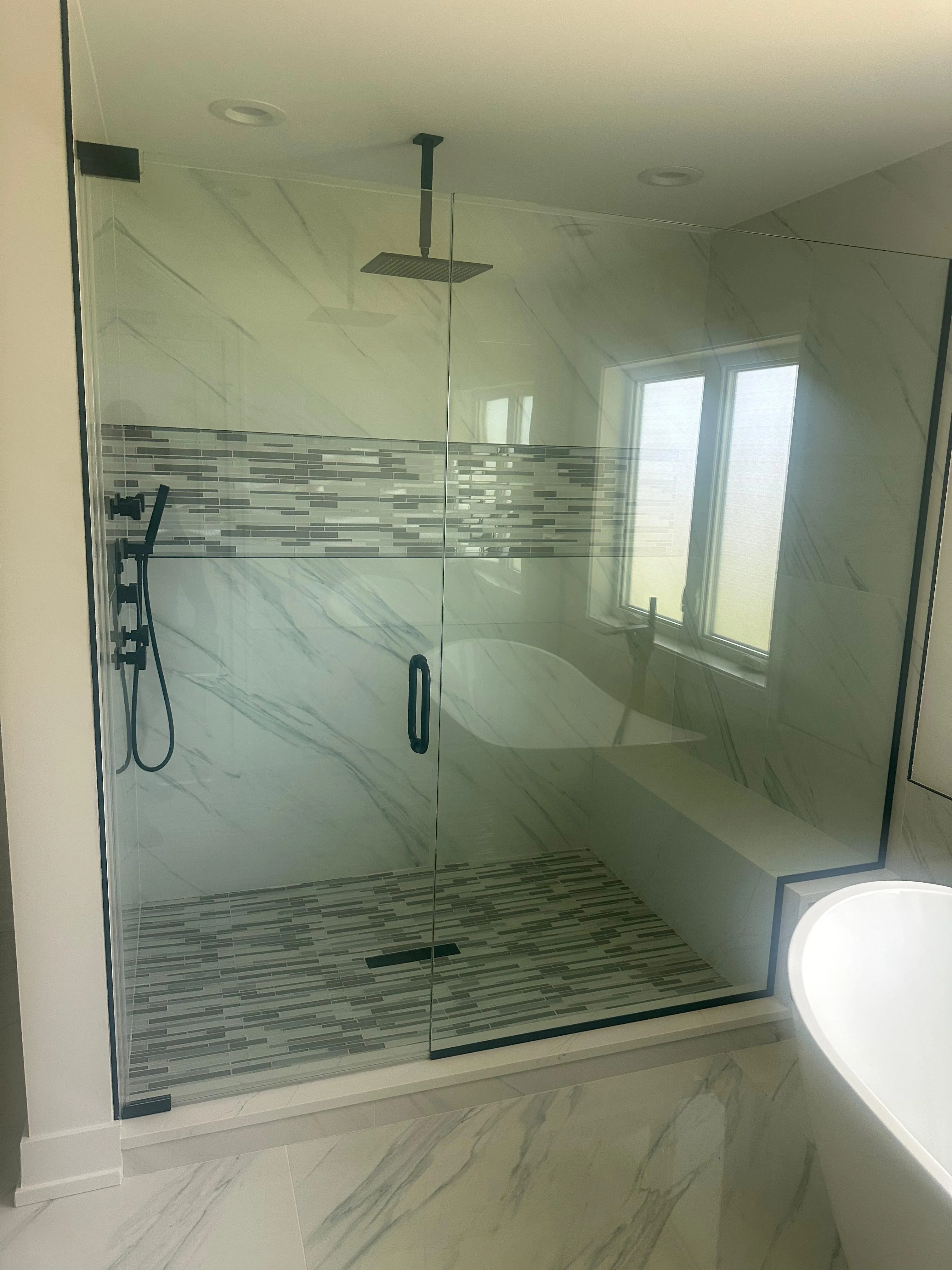 Frameless glass shower with mosaic accent tile installed by Artix Glass & Cabinetry
