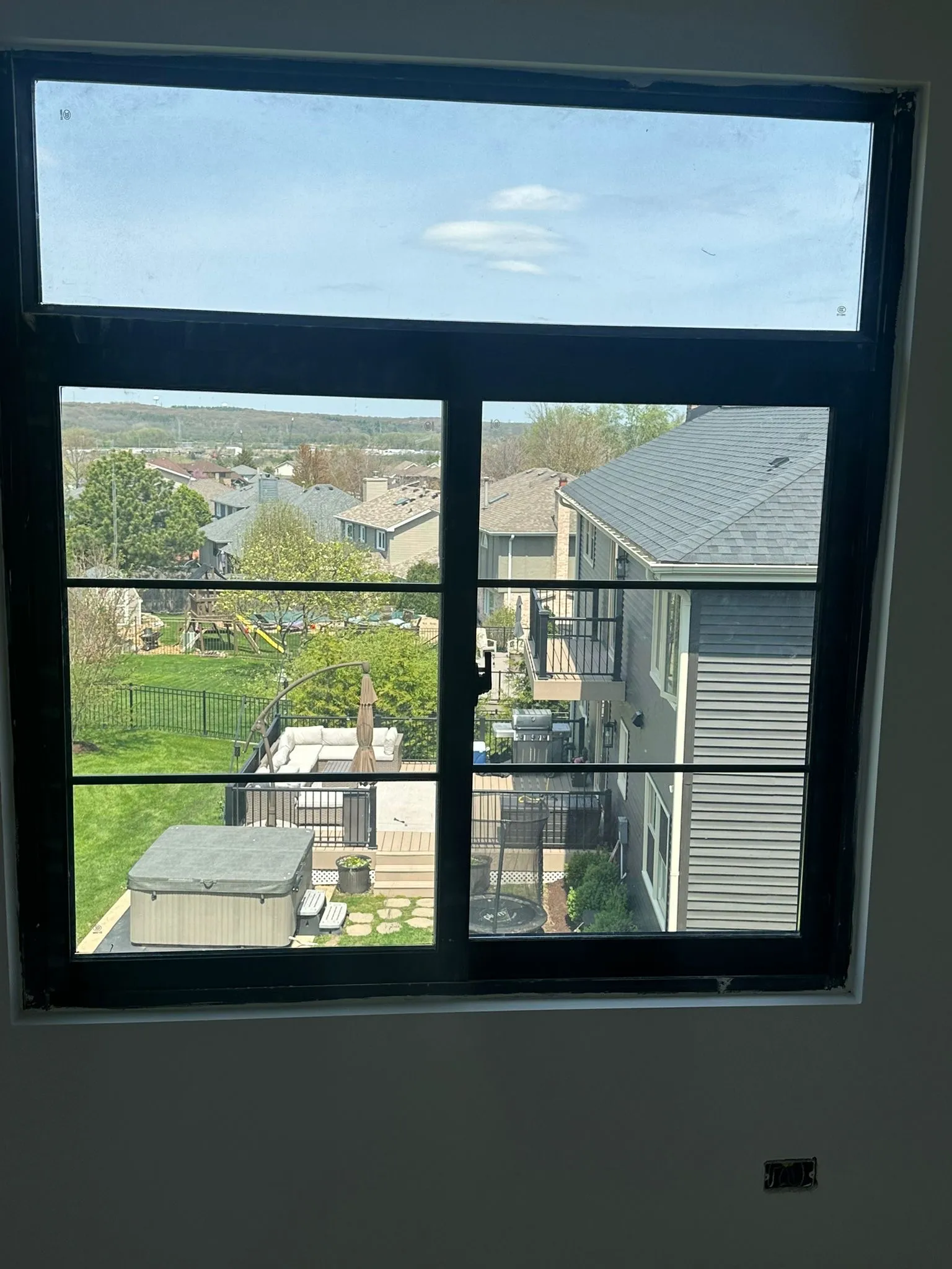 Black-frame double-hung window installed in a two-story home