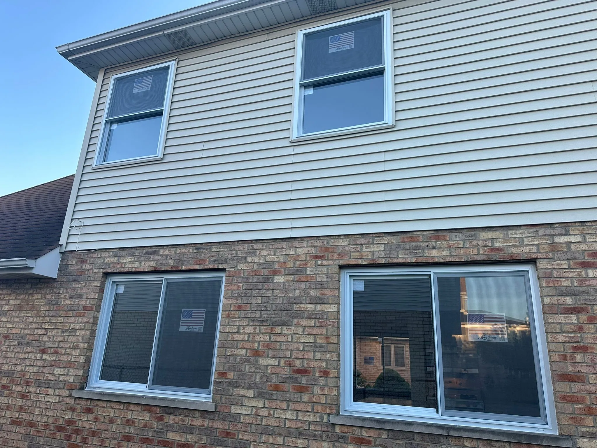 New vinyl windows on a re-sided residential exterior