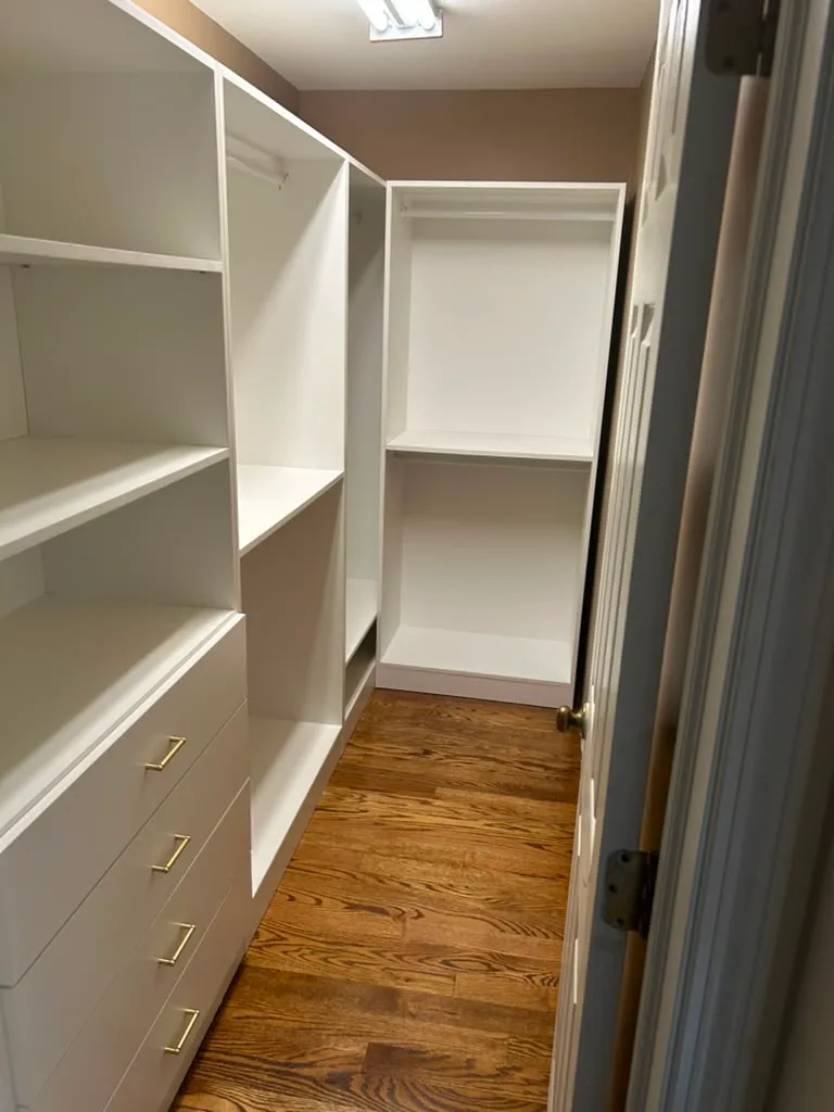 Finished walk-in closet with custom cabinetry and drawers